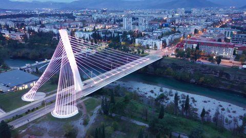 Podgorica Montenegro at night, featuring illuminated cable-stayed Millennium bridge over Moraca river. Aerial panorama of the capital of a small country in the Balkans, south east Europe.