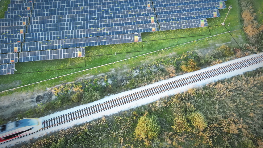 Aerial view of solar panels generating electricity connect to train power lines. Clean, green, renewable energy technologies. Power battery charge Animated graphics eco concept | Shutterstock HD Video #1061865535