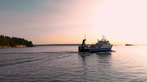 A large fishing vessel leaving Vancouver harbor at sunset. 4K 24FPS.