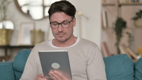 Portrait of Video Call on Tablet by Middle Aged Man at Home 