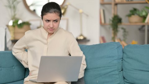 Laptop work by Indian Woman with Back Pain on Sofa 