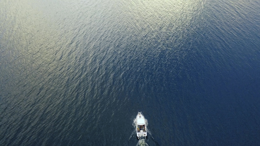 Aerial view moving fishing boat at the ocean. Top view sailing fishing boat. Aerial view fishing motor boat with angler. Ocean sea water wave reflections. Motor boat in the ocean. Royalty-Free Stock Footage #1061875720