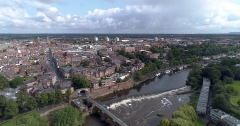 Aerial track shot of the River Dee above a weir in Chester, England