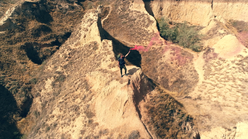 The tourist with a smoke stick standing on the mountain top