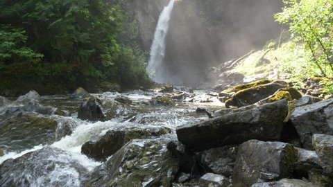 Wide, misty waterfall in a canyon with trees, British Columbia, Canada