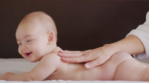 Mom Gives Back Massage To Her Little Child. Closeup.