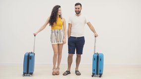 4k video of couple standing with blue suitcases over white background.