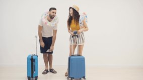 4k slowmotion video of joyful couple with suitcases for vacations together.