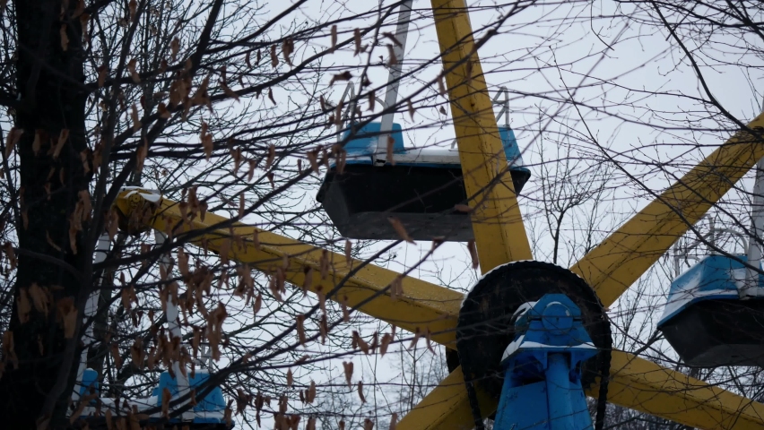 Old childrens carousel in an abandoned amusement park in winter with snow 