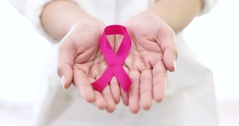 Pink ribbon in the hand of an Asian woman, Breast cancer, International women day and World cancer day concept.