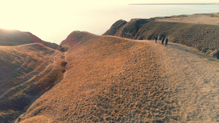 The four travelers walking on the mountain range on the beautiful sea background