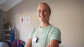 Tilt down shot of a young female physiotherapist standing in rehabilitation center with her arms crossed - Powered by Shutterstock - Get 15% off with code: PIKWIZARD15