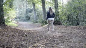 Medium shot woman walking alone in the forest. Backlight, slow motion 4K