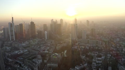 Slow Aerial Drone backwards wide view of Frankfurt am Main, Financial City in Germany in beautiful yellow Sunset light and Haze