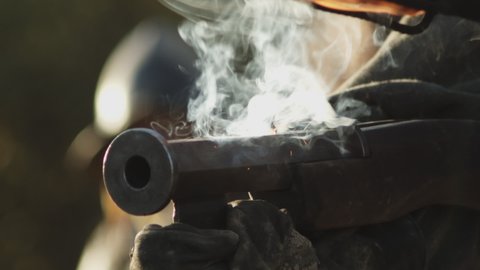 Old medieval handgun extreme closeup, wick and torch set fire of gunpowder, front view shooting slow motion