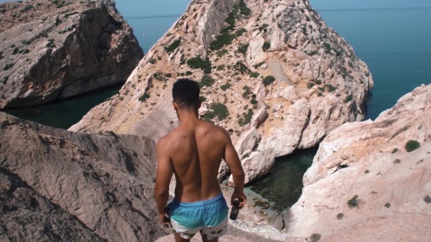 A guy with no t-shurt going down to the beach in El Jebha beach Morocco. summer vacation. Exploring Morocco.