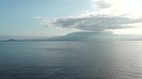 Fernandina Volcano with Clouds Overhead and Ripples from Jumping Dolphins in the Water in the Galapagos Islands