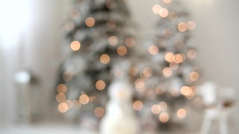 Defocused Christmas tree with lights and ornaments. Blurred silhouette of a Christmas tree with lights glowing. Cozy abstract Christmas concept. Happy new year 2022.