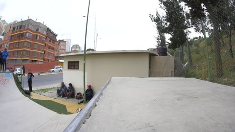 La Paz / Bolivia - November 23 2015: A Young Brown Man is Skating in a Park with a Half Pipe in a Slow Motion