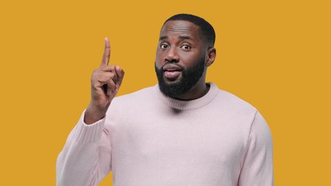 Great idea. African guy raised index finger up came up with great cool fresh idea feels looking at camera isolated on yellow background, understanding concept
