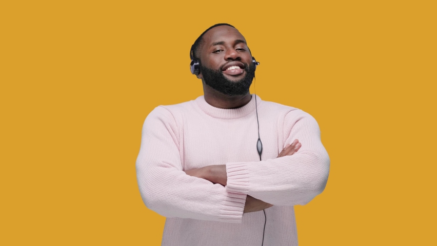 Smiling african american man wearing wireless headset looking at the camera, call center service. isolated on yellow background Royalty-Free Stock Footage #1061920477