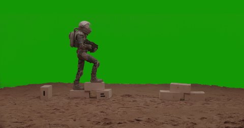 GREEN SCREEN CHROMA KEY Astronaut walking with a gun on a sandy surface. Alien planet colonization concept