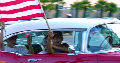 LOS ANGELES, CALIFORNIA, USA - OCTOBER 17, 2020: Trump supporters in vintage classic car with American flags participate in rally in Beverly Hills, Los Angeles, California, 4K