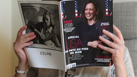 Paris, France - Nov 5, 2020: Woman reading in living room the latest Elle Magazine featuring on cover Kamala Harris Democratic vice presidential nominee for the 2020 election