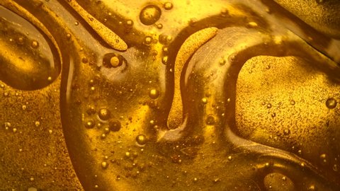 Liquid gold abstract background. Flowing Golden abstract backdrop. Beautiful metallic yellow texture. Liquid gold Art Wallpaper. Flowing Surface. 4K UHD slow motion