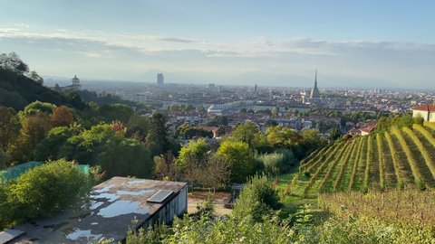 Panoramic view of Turin at sunset, with Mole Antonelliana, Vittorio's Square, and the Queen's vineyard at the forefront.