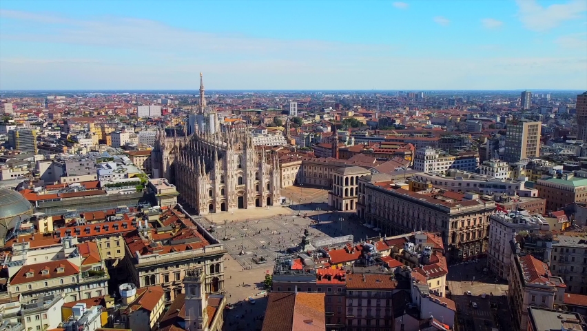 Aerial view of Piazza Duomo in front of the gothic cathedral in the center. Drone view of the gallery and rooftops during the day. Flight over the city. People in the city. Milan. Italy 2020 Royalty-Free Stock Footage #1061944258