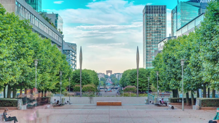 Skyscrapers of La Defense timelapse - Modern business and residential area in the near suburbs of Paris, France. Arc de Triomphe with Champs Elysees on background. Green trees, blue cloudy sky at Royalty-Free Stock Footage #1061946367