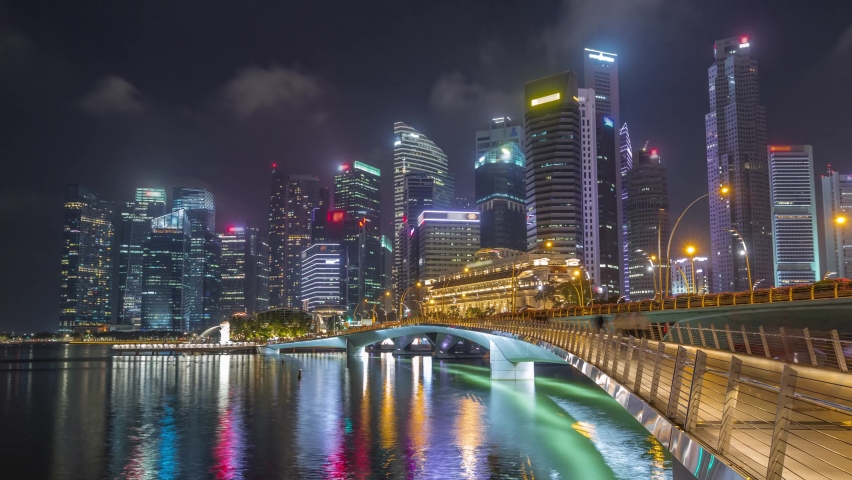 Esplanade bridge and downtown core skyscrapers in the background Singapore night timelapse hyperlapse. Illuminated towers reflected in water
