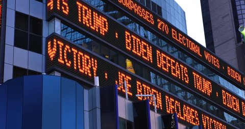 WASHINGTON DC - Circa November, 2020 - A fictional New York City Times Square news ticker on the side of a tall building reports that Joe Biden defeats Donald Trump for presidency in the 2020 election