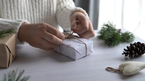 Zero waste Christmas gift wrapping, woman wrap present with eco-friendly Christmas decoration, preparation for holiday season. 