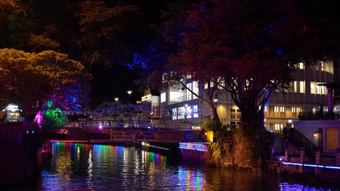 Melaka,Malaysia- Circa November 2020:  Colourful "Melaka River" bridge at night surrounded by old trees