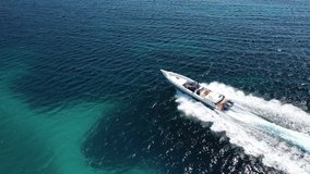 Aerial drone tracking video of inflatable rib speed boat cruising in high speed in deep blue Aegean sea