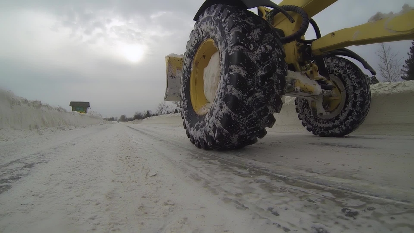 Snow Plow Clearing Icy Road After Snowstorm. Winter Road Maintenance and Safety.