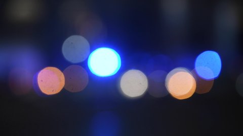 Intentionally blurred footage of emergency motor vehicles with blue lights in the city traffic at night during the Covid-19 coronavirus outbreak.