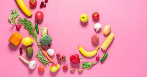 Fresh organic vegetables and fruits move into a pile on a pink background, stop motion. Vegetables animation. 
Flat lay 4 video with vegetables.
