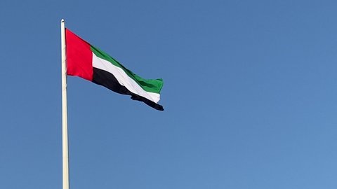 UAE Flag,United Arab Emirates Flag waving in the wind.Blue sky background.UAE National day.UAE Flag day.4k