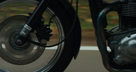 EXTREME CU TRACKING Biker riding his custom built vintage retro motorcycle on a scenic forest road. Shot on RED cinema camera with 2x Anamorphic lens