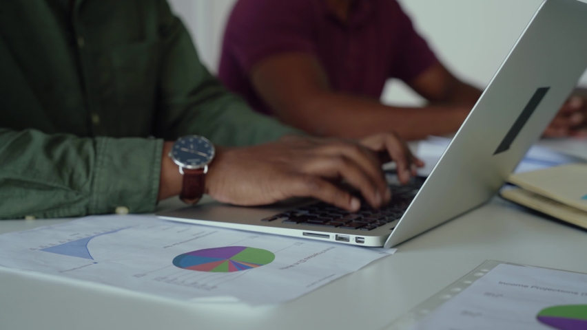 Male accountant checking pie charts logging in figures onto spreadsheet on laptop sitting in conference room | Shutterstock HD Video #1061961907