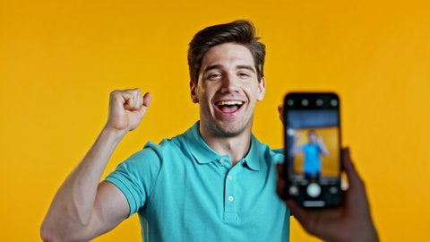 человек, записывающий видео на телефон с улыбкой