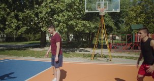 Friends play basketball while making a freeze motion in the court