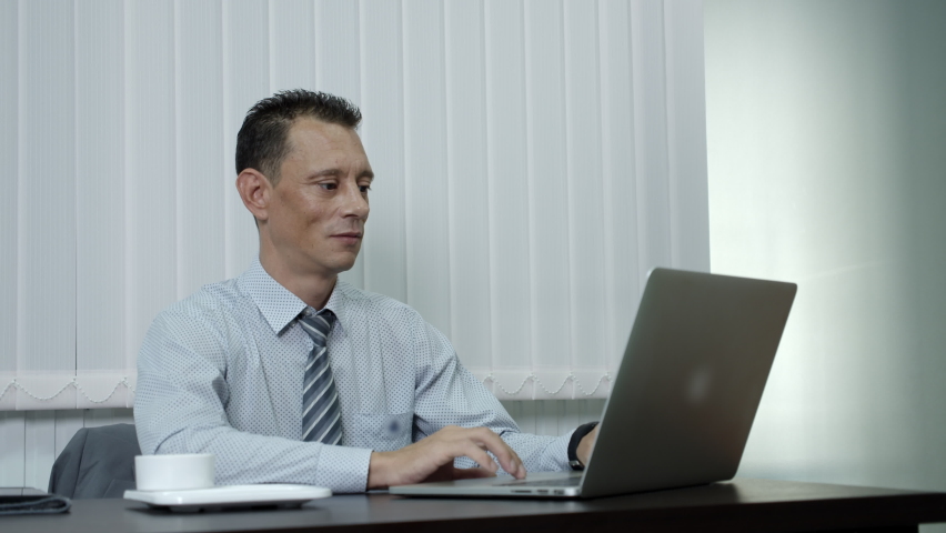 A business man who is a company employee using a laptop to work in an office was excited, made a look of success, shouted YES aloud.