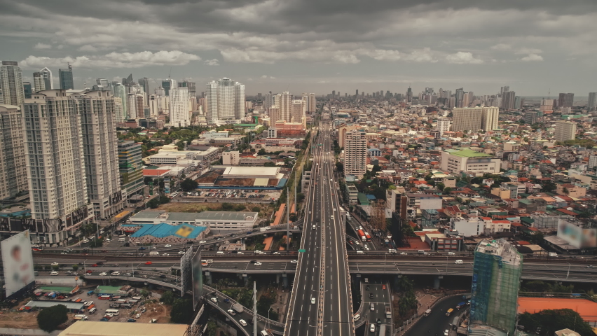 Traffic bridge highway at modern skyscrapers aerial. Epic cityscape with streets along road. Block buildings and cottages at cloudy summer day. Downtown local transportation at Manila city, Philippine