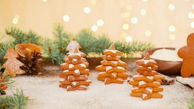 Christmas gingerbread in the shape of a Christmas tree and a star is sprinkled with powdered sugar against the light of bokeh garlands. soft focus on gingerbread, sugar levitation.