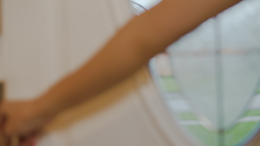 Little girl celebrates a Covid-19 Safe Halloween by trick-or-treating while wearing a mask. Door opens to reveal girl in witch costume wearing a mask for protection.