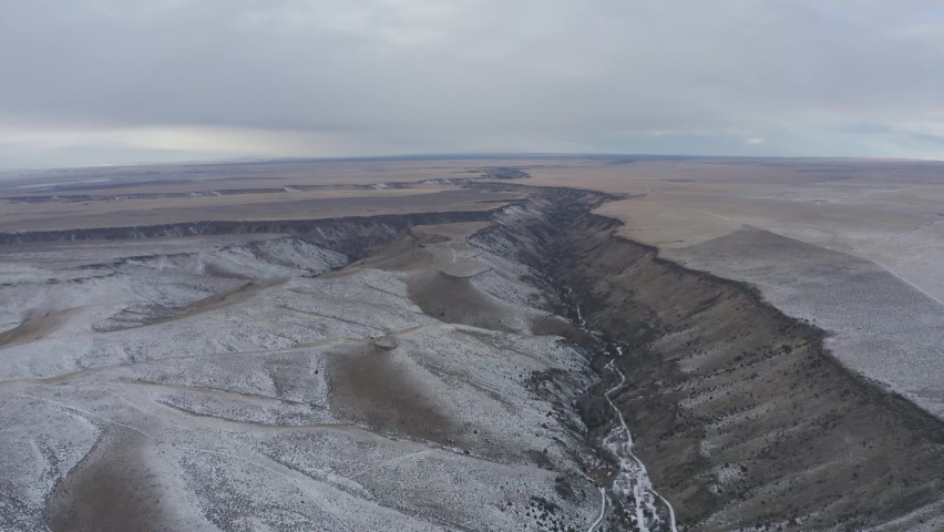 Snowy canyon winter drone shot of expansive plains